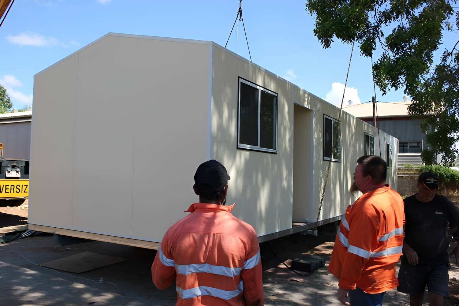 A Group of People Standing Beside the Newly Container House — Downright Carpentry in Ryan, QLD