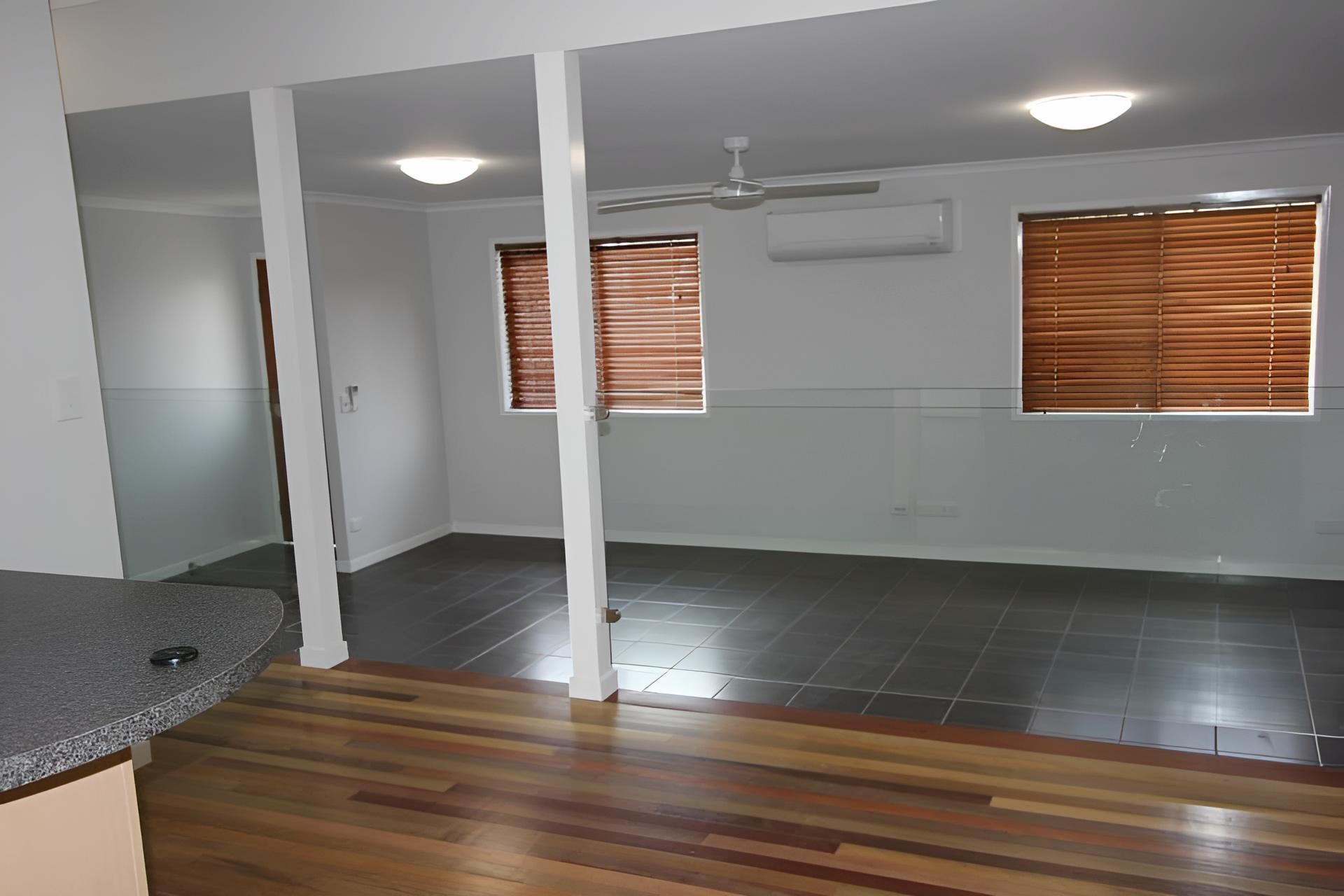 An Empty Room With Wooden Floors and a Ceiling Fan — Downright Carpentry in Miles End, QLD