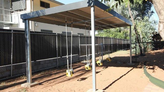 Playground With Swings Under a Canopy in Front of a House — Downright Carpentry in Ryan, QLD