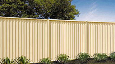 Beige Fence is Surrounded by Plants and Trees in a Yard — Downright Carpentry in Ryan, QLD