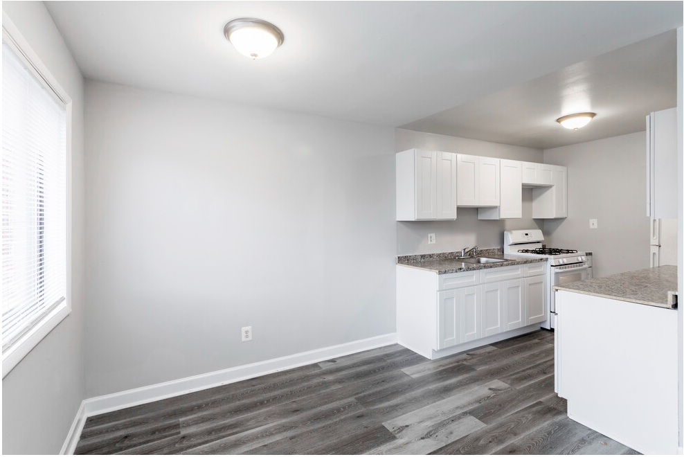 Upgraded kitchen with granite countertops and grey flooring and view of dining area
