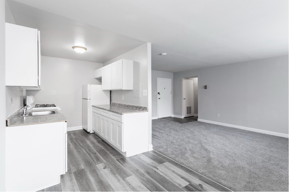 Upgraded kitchen with granite countertops and grey flooring and view of living room