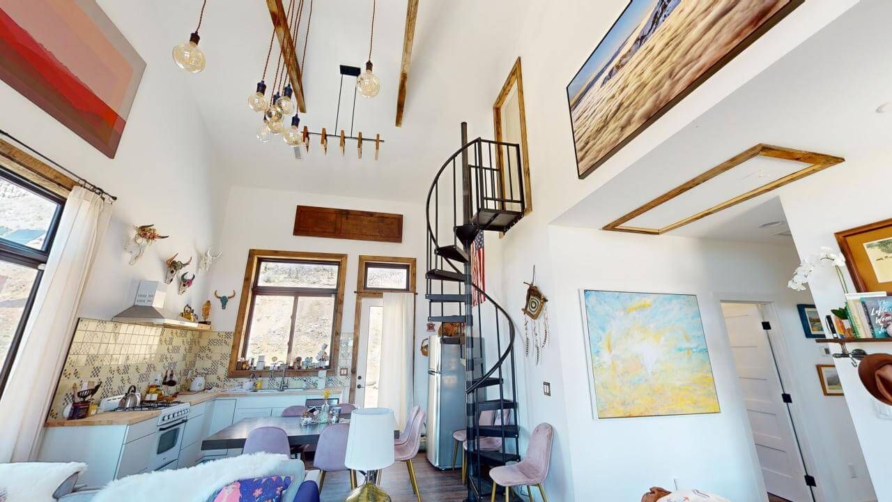 A living room with a spiral staircase leading to the second floor. Maven Construction, Montrose, CO