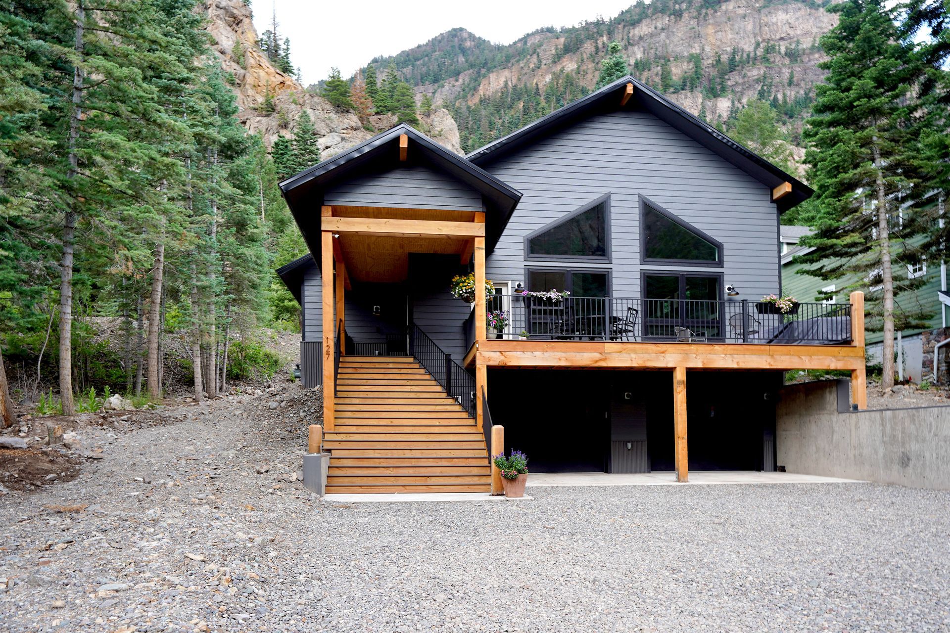 A large house with a large deck in the middle of a forest Maven Construction, Montrose, CO
