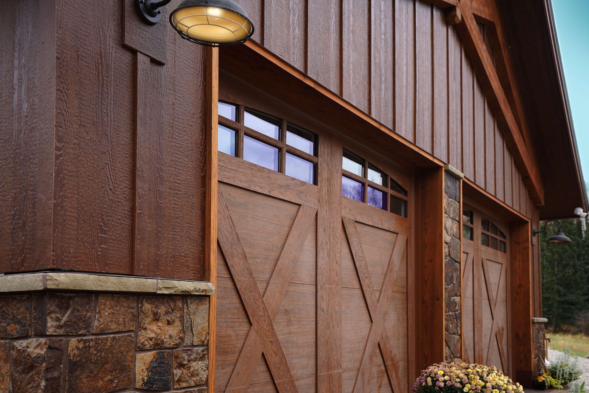 A wooden garage door with a light on the side of it. Maven Construction, Montrose, CO