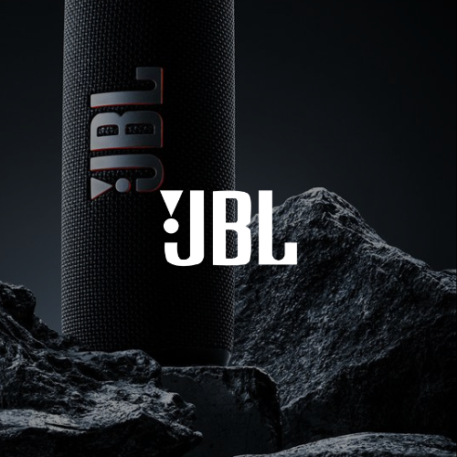 Altavoz JBL negro con logotipo JBL blanco sobre rocas escarpadas en un entorno oscuro y melancólico.