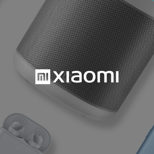 Altavoz y auriculares Xiaomi sobre una superficie gris con el logo de Xiaomi.