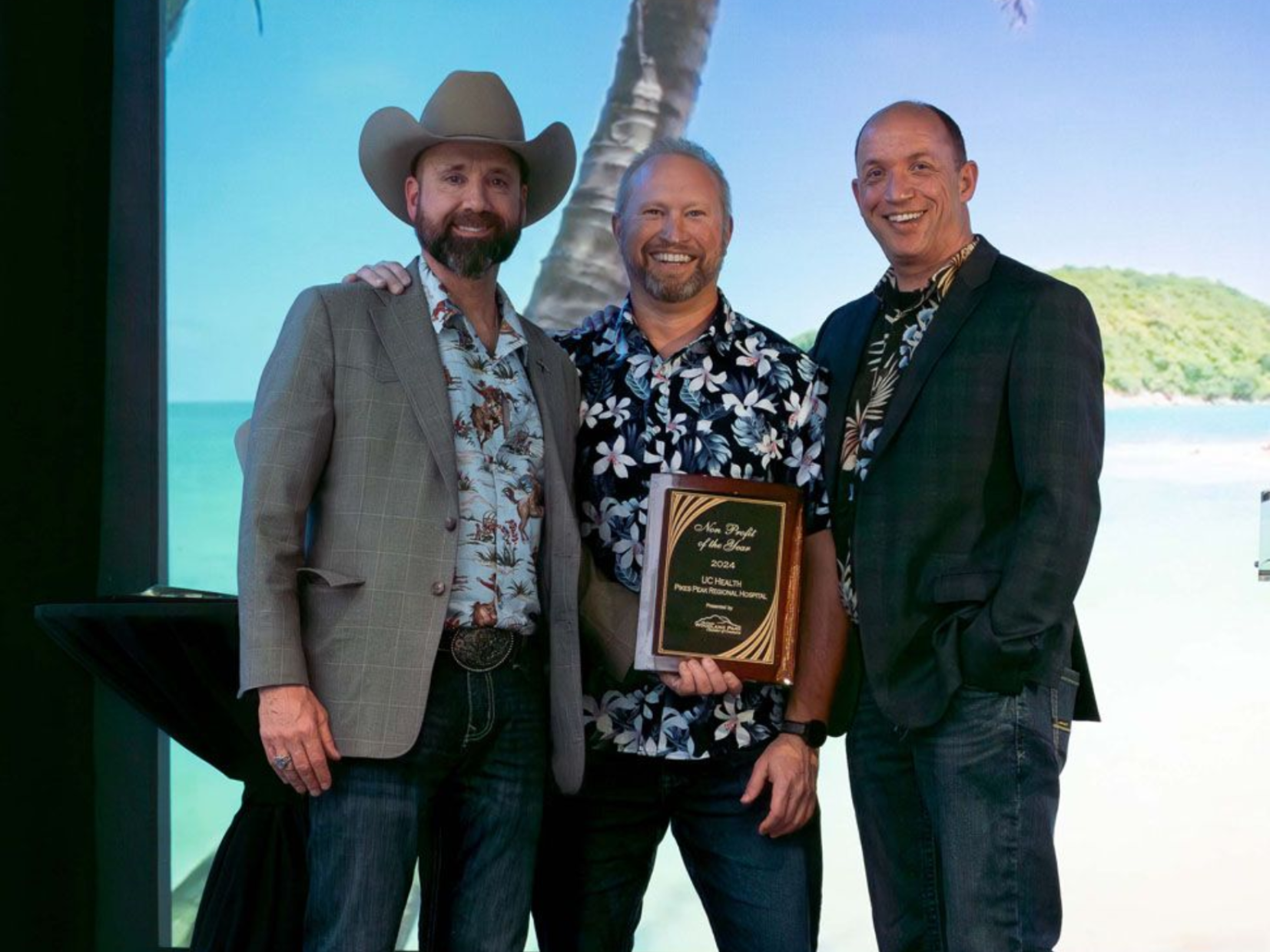 Three men on stage accepting an award