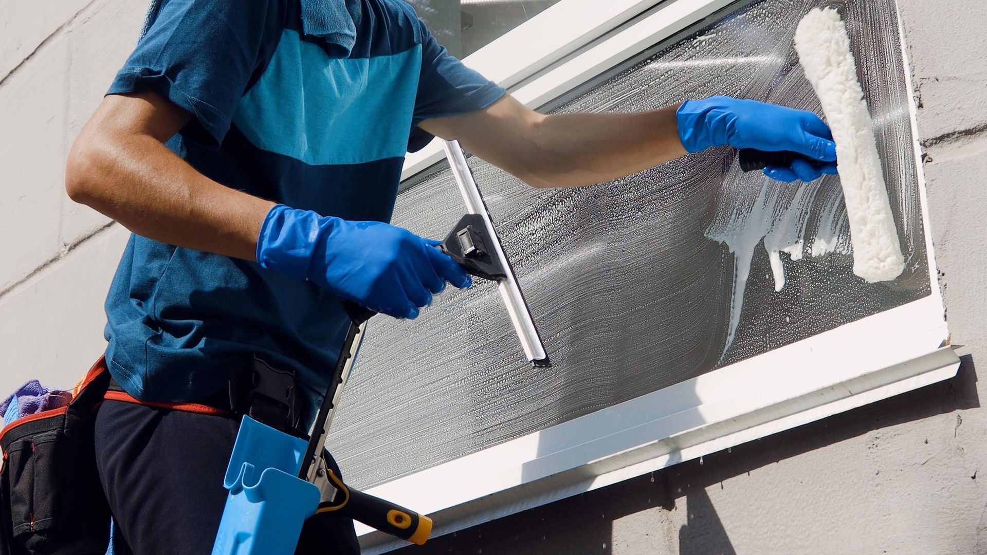 A man is cleaning a window with a squeegee.