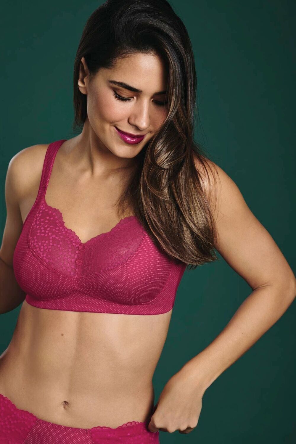 Une femme porte un soutien-gorge rose et des sous-vêtements rouges.