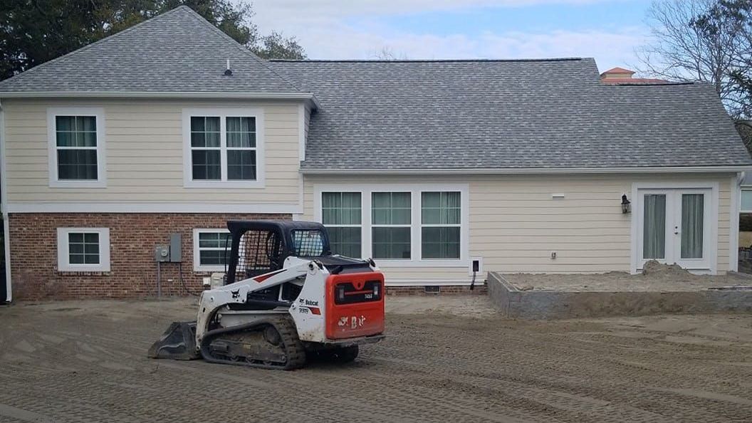 A bulldozer is parked in front of a house.