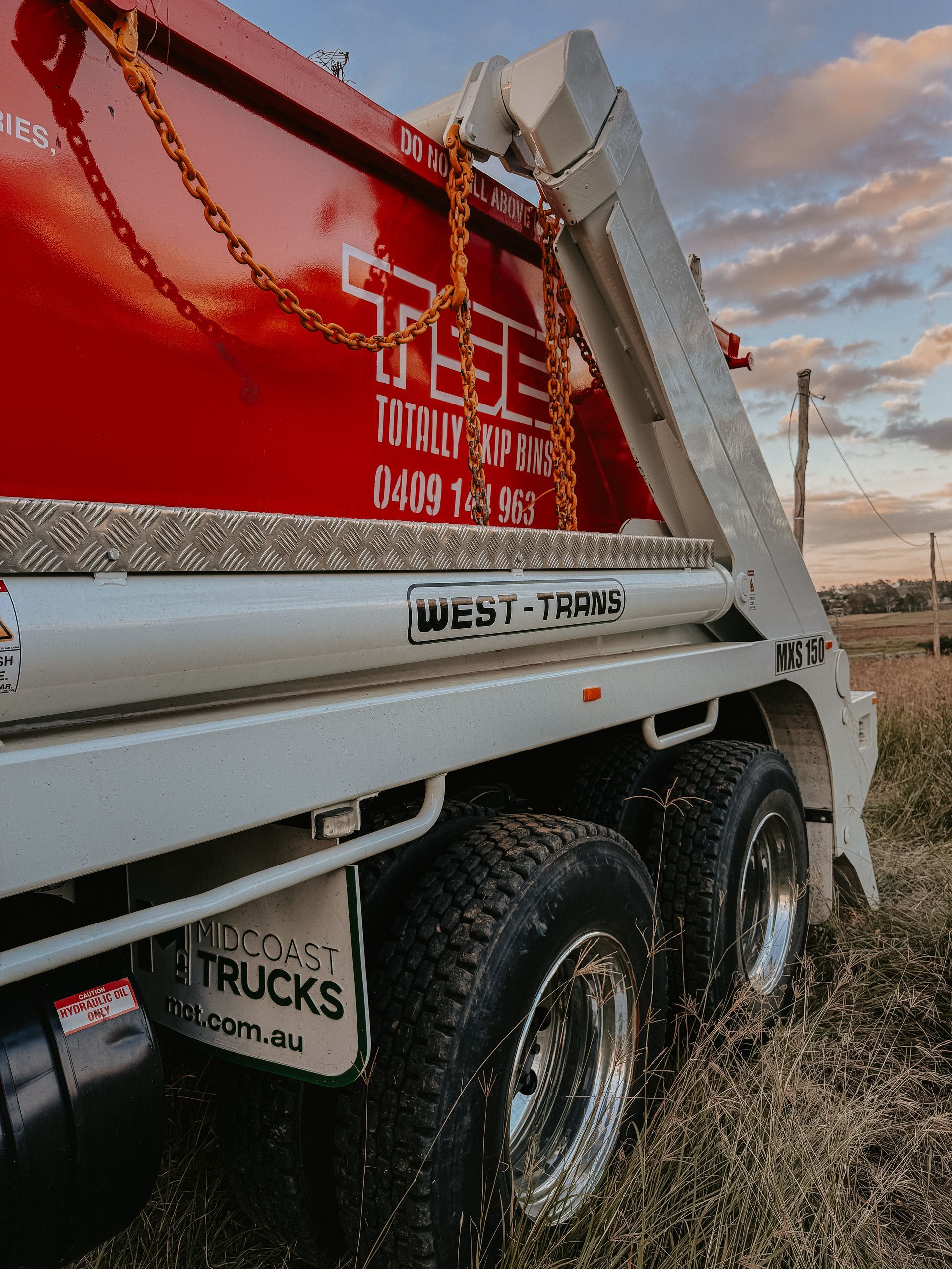 A Red and White Dump Truck is Parked in a Dirt Lot — Totally Skip Bins in Palen Creek, QLD