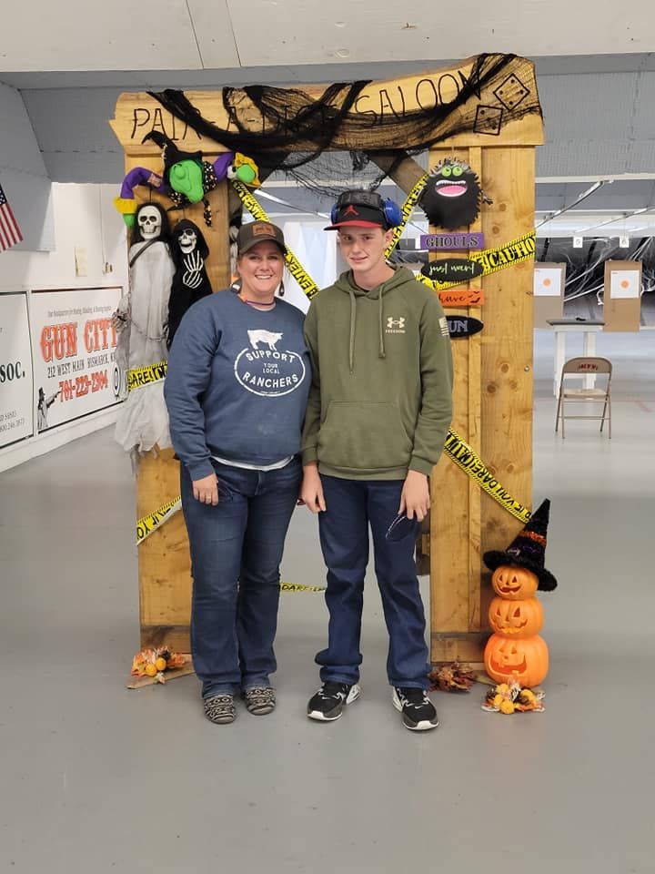 A man and a woman are posing for a picture in front of a halloween decoration.