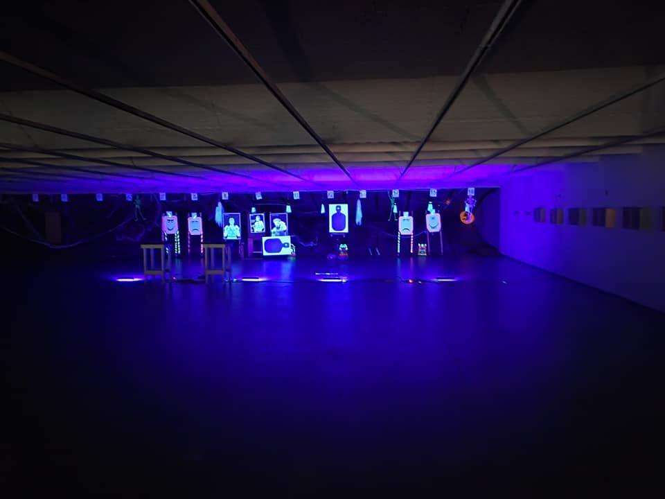 A dark room with purple lights on the ceiling and floor.