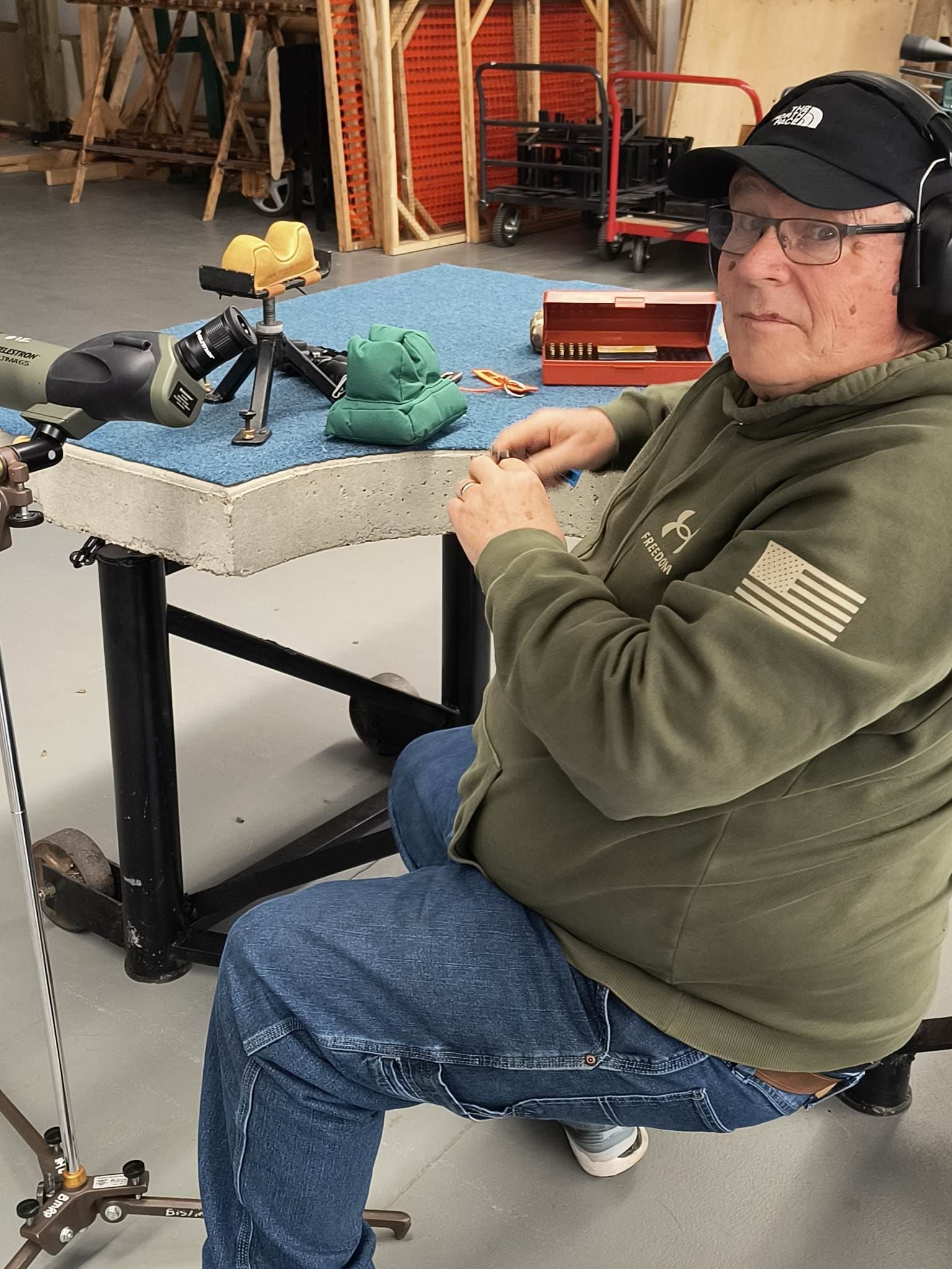 A man wearing headphones and a hat is sitting at a table.