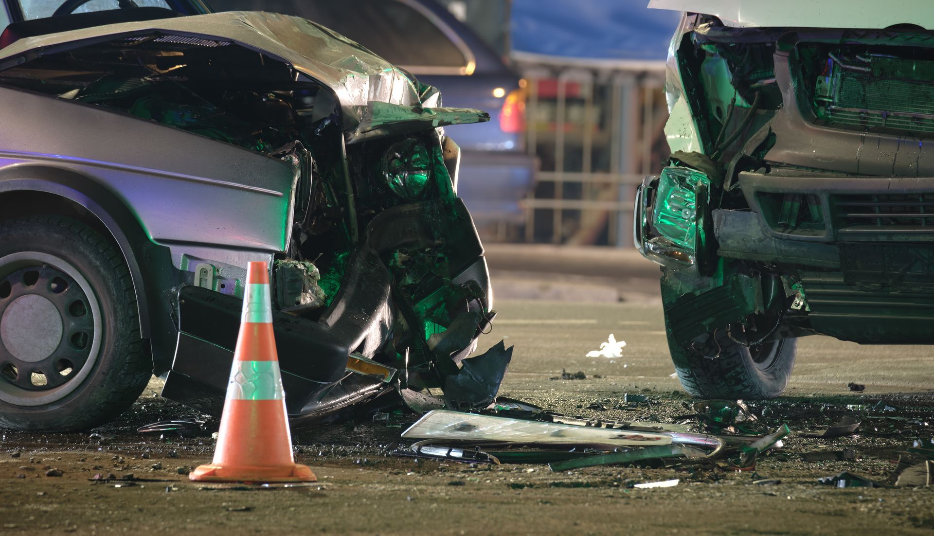 Man in suit protecting a toy green car with his hands, next to scales of justice and gavel.