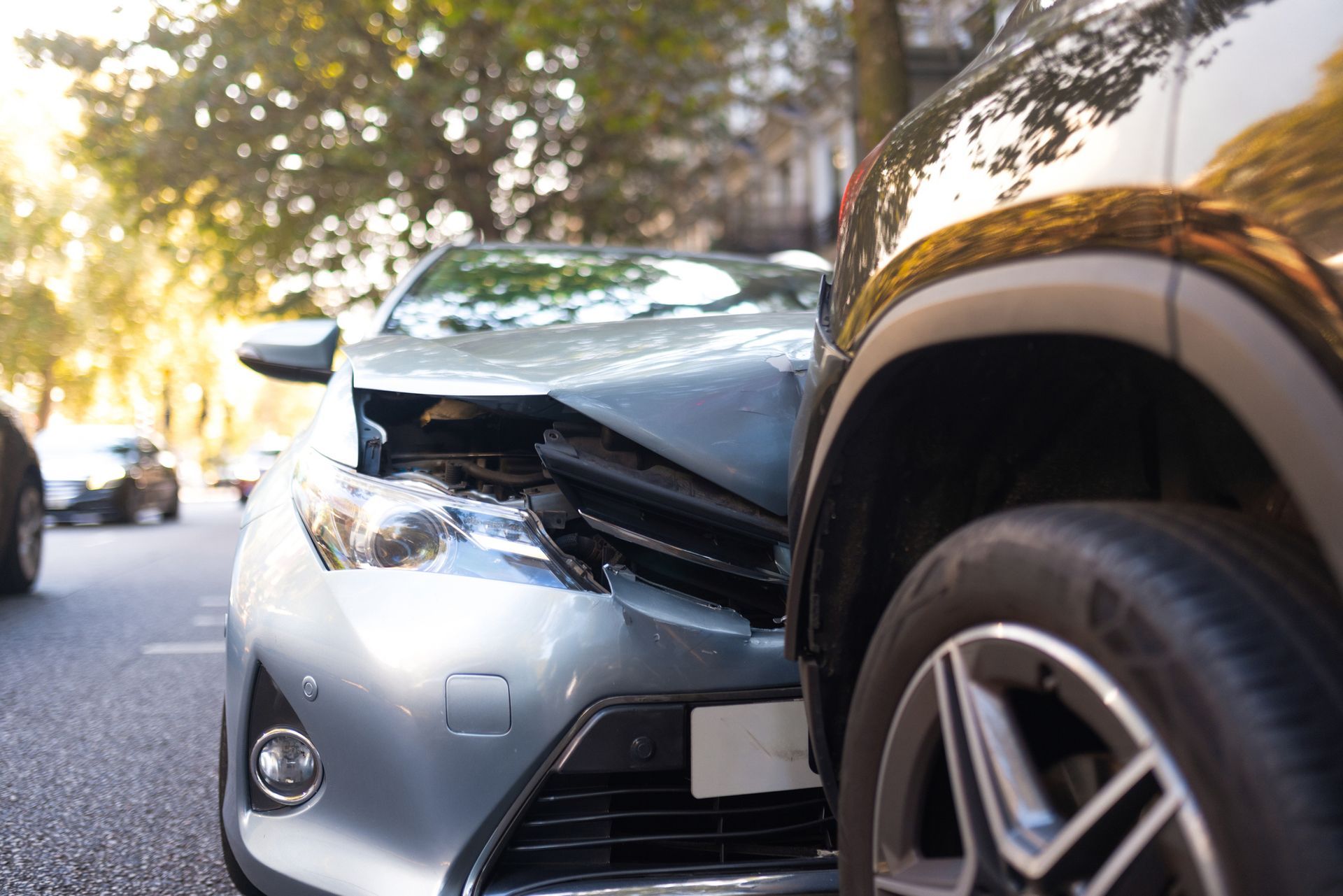 Two cars damaged in a collision on a city street.