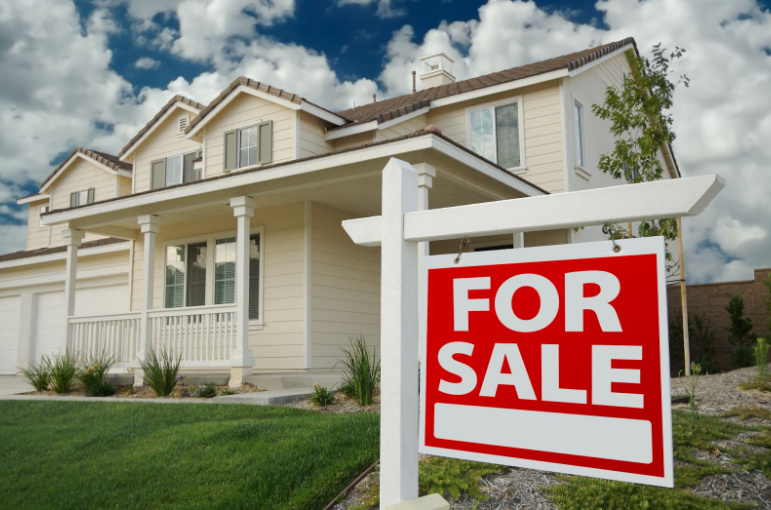 A house with a for sale sign in front