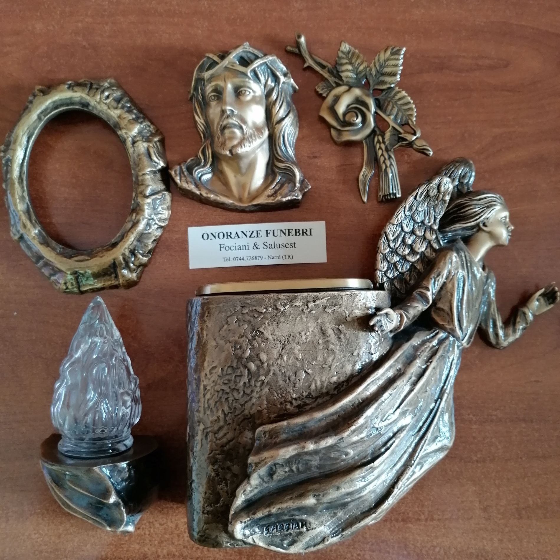 Assortimento di sculture e cornici decorative color argento disposte su una superficie di legno
