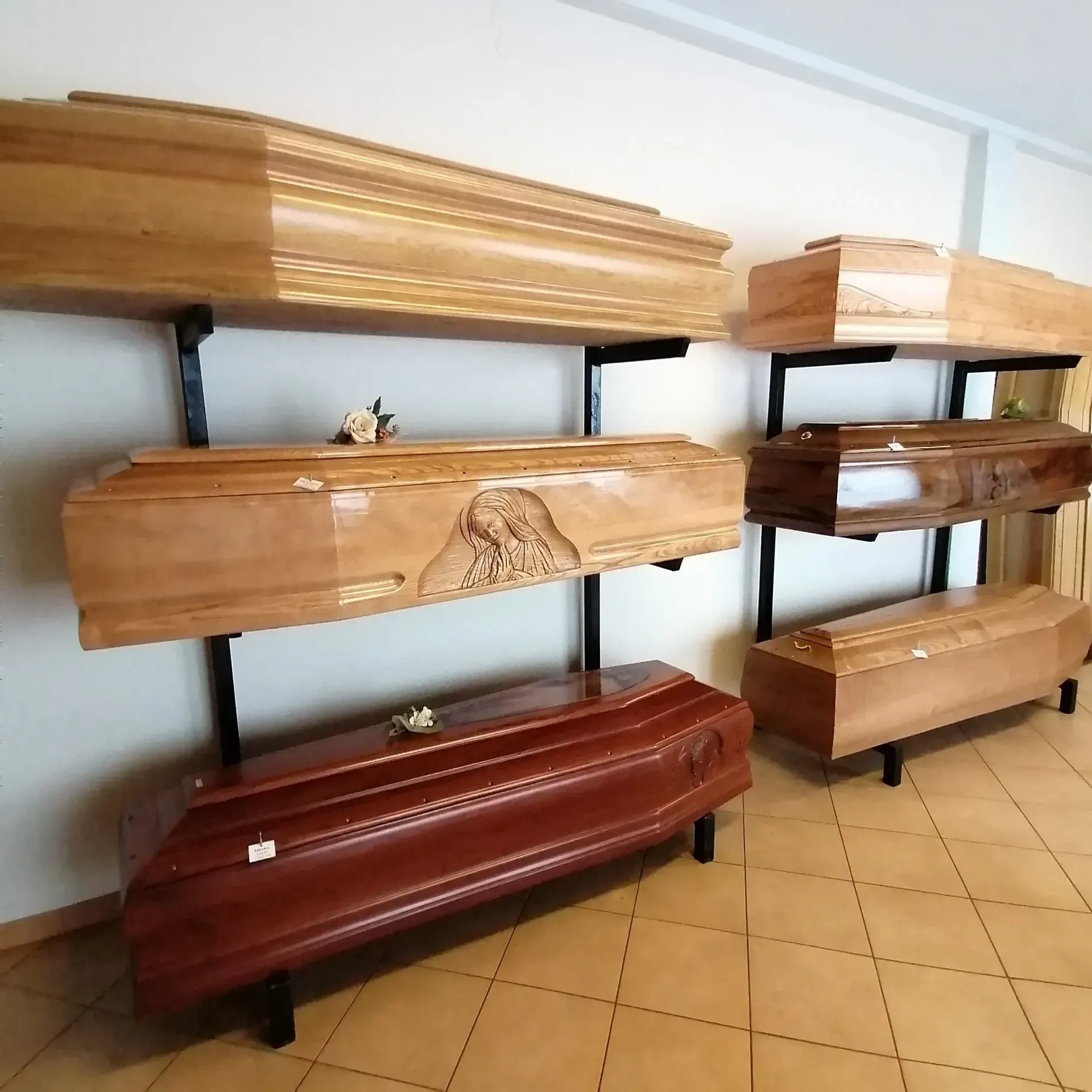 Bare di legno esposte su supporti neri in uno showroom o in una camera ardente