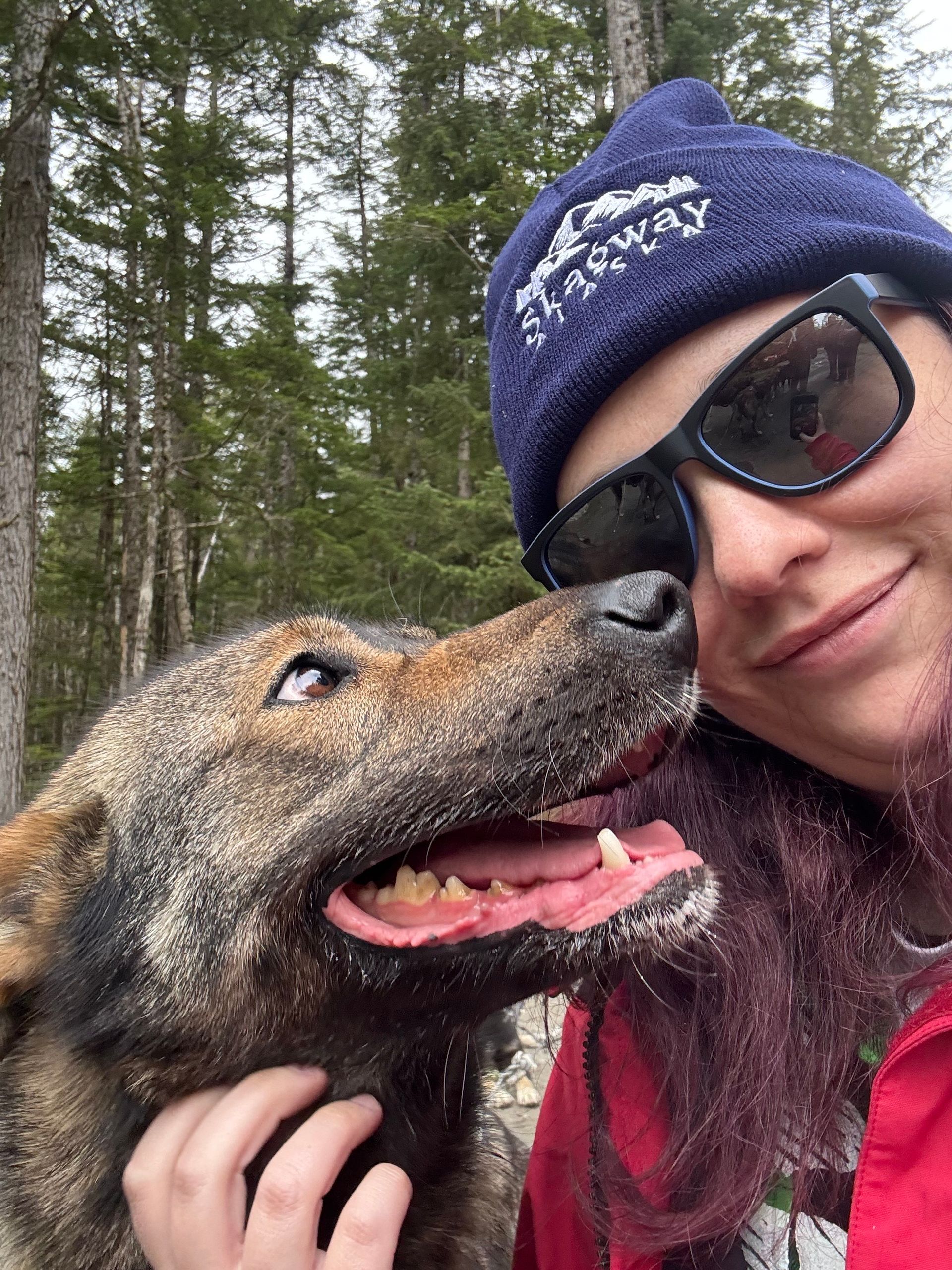 Young woman smiling with her rescue dog in the forest