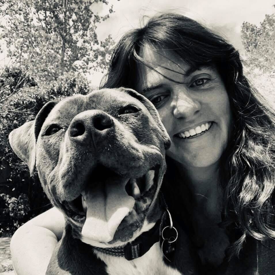 Smiling woman and her joyful rescue dog pitbull in black and white.