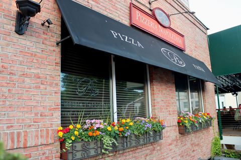A brick building with a sign that says pizza on it