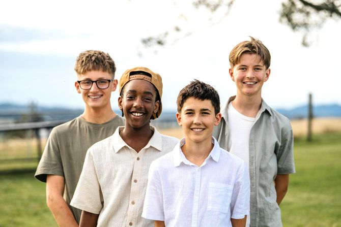 A group of young men are posing for a picture in a field