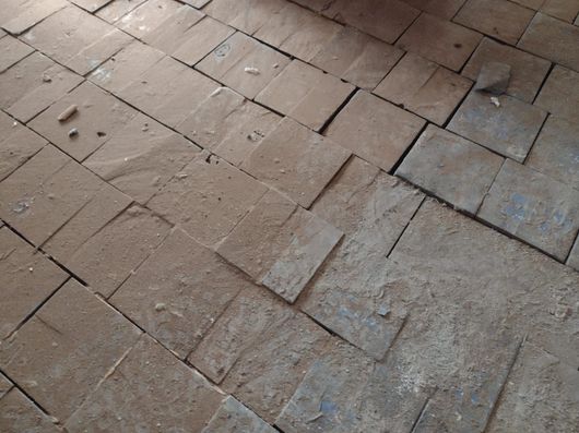 Un primer plano de un piso de ladrillo con una roca en el medio.
