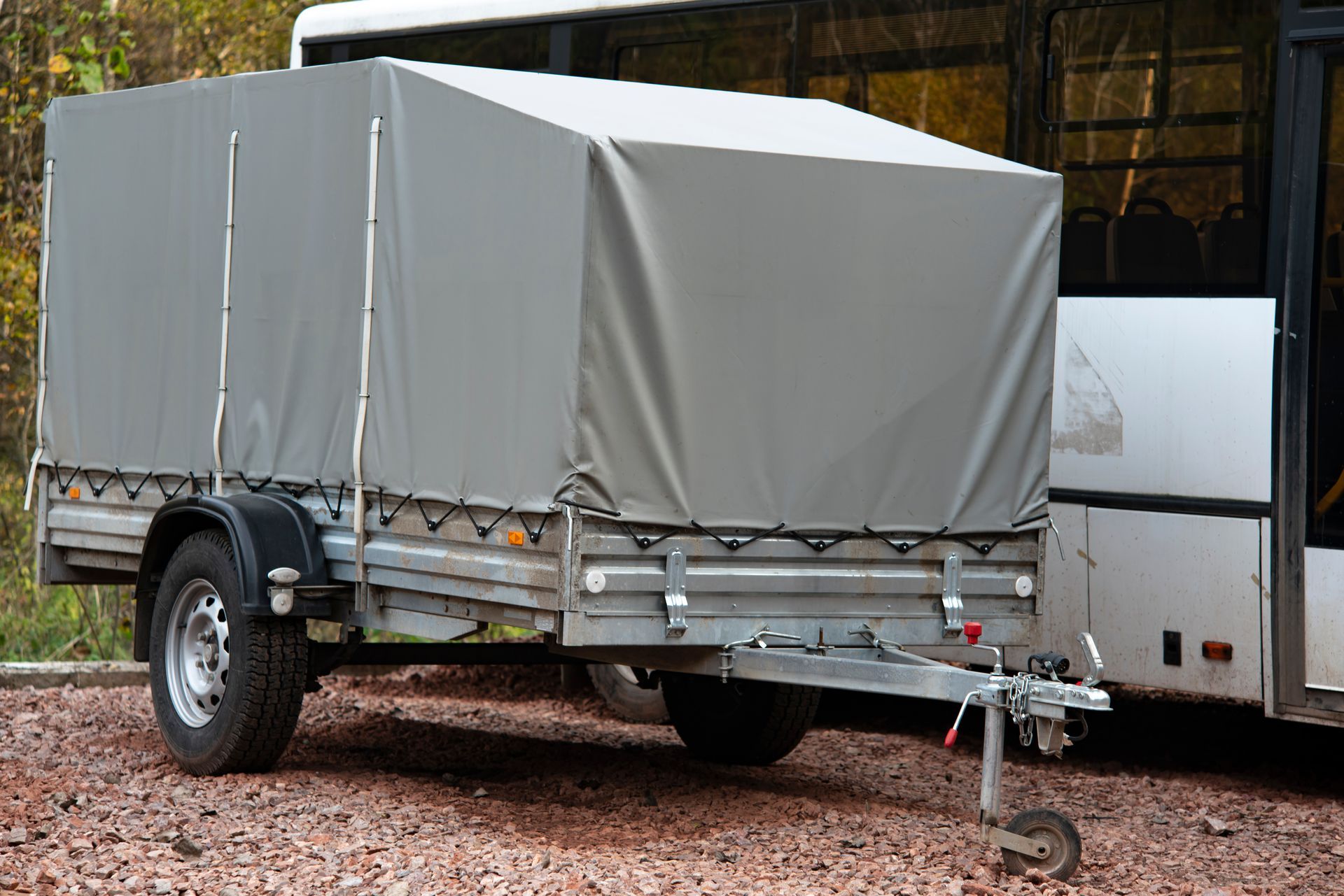 Truck with a covered trailer parked beside a warehouse loading area