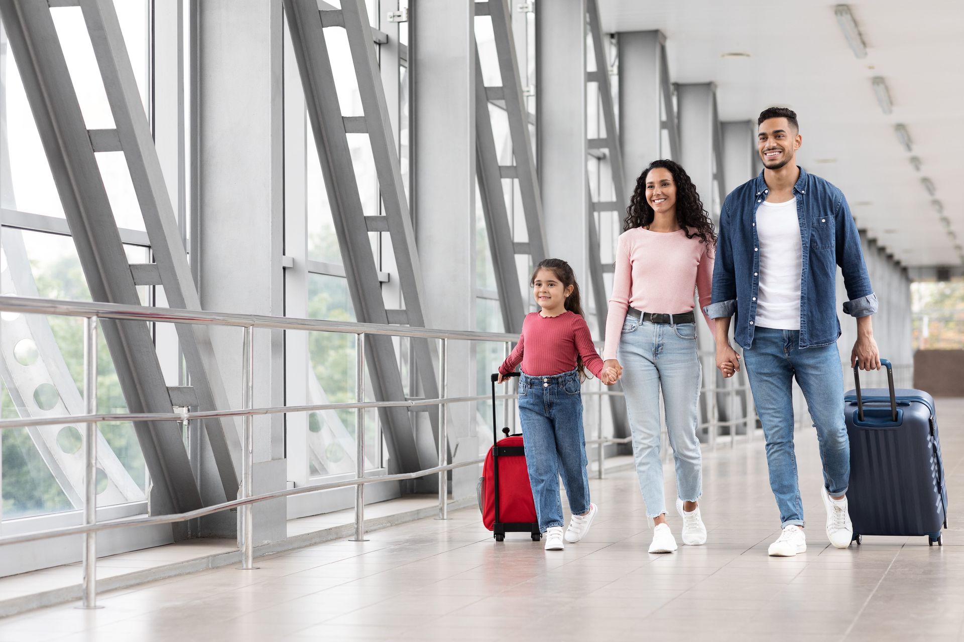 Family walking with luggage through a bright airport terminal
