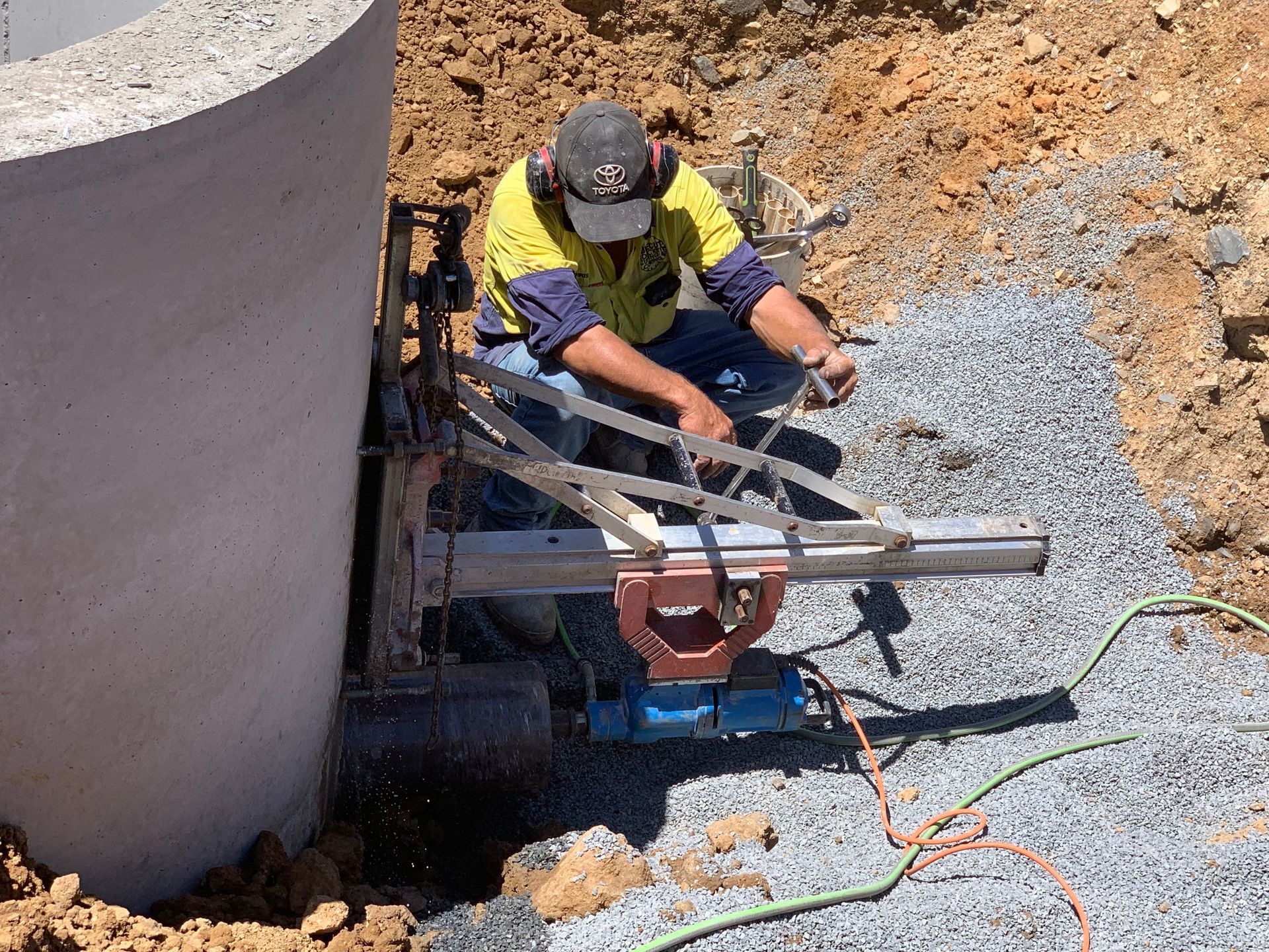 Worker operating equipment beside a large concrete pipe at a construction site — Ablecut Concrete Cutting & Coring In East Mackay, QLD