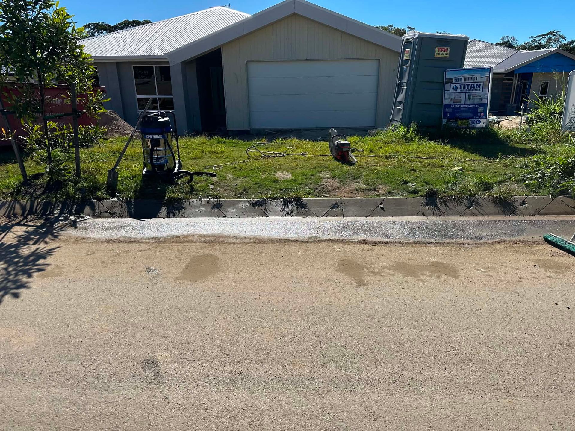 Suburban house with garage, small front lawn, and curbside driveway under bright sun — Ablecut Concrete Cutting & Coring In East Mackay, QLD