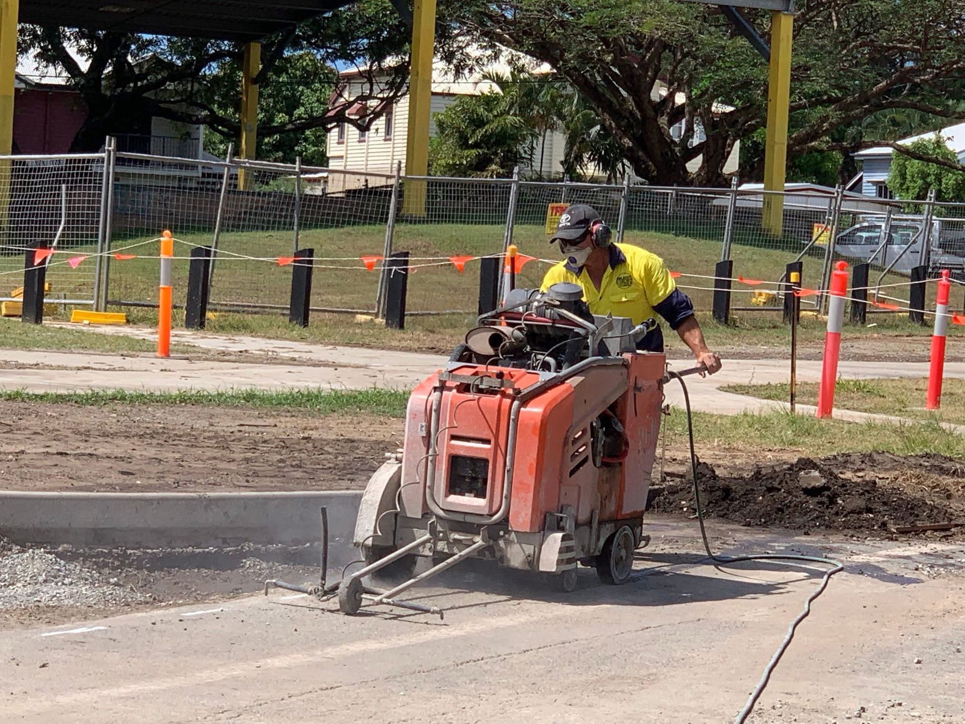 Construction Worker Cutting Concrete Near a Building — Ablecut Concrete Cutting & Coring In Sarina, QLD