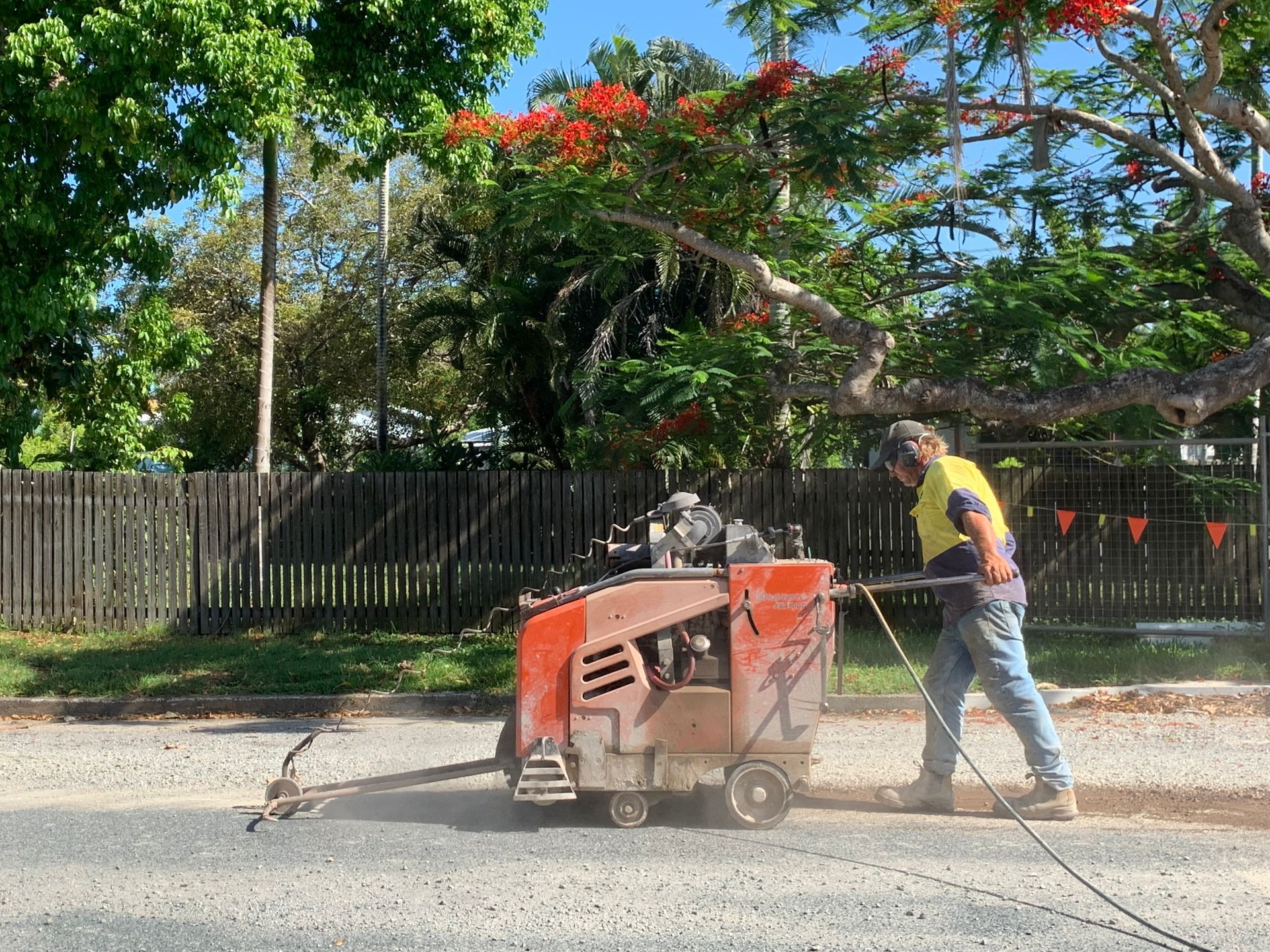 Man Operating a Concrete Saw on a Street — Ablecut Concrete Cutting & Coring In East Mackay, QLD