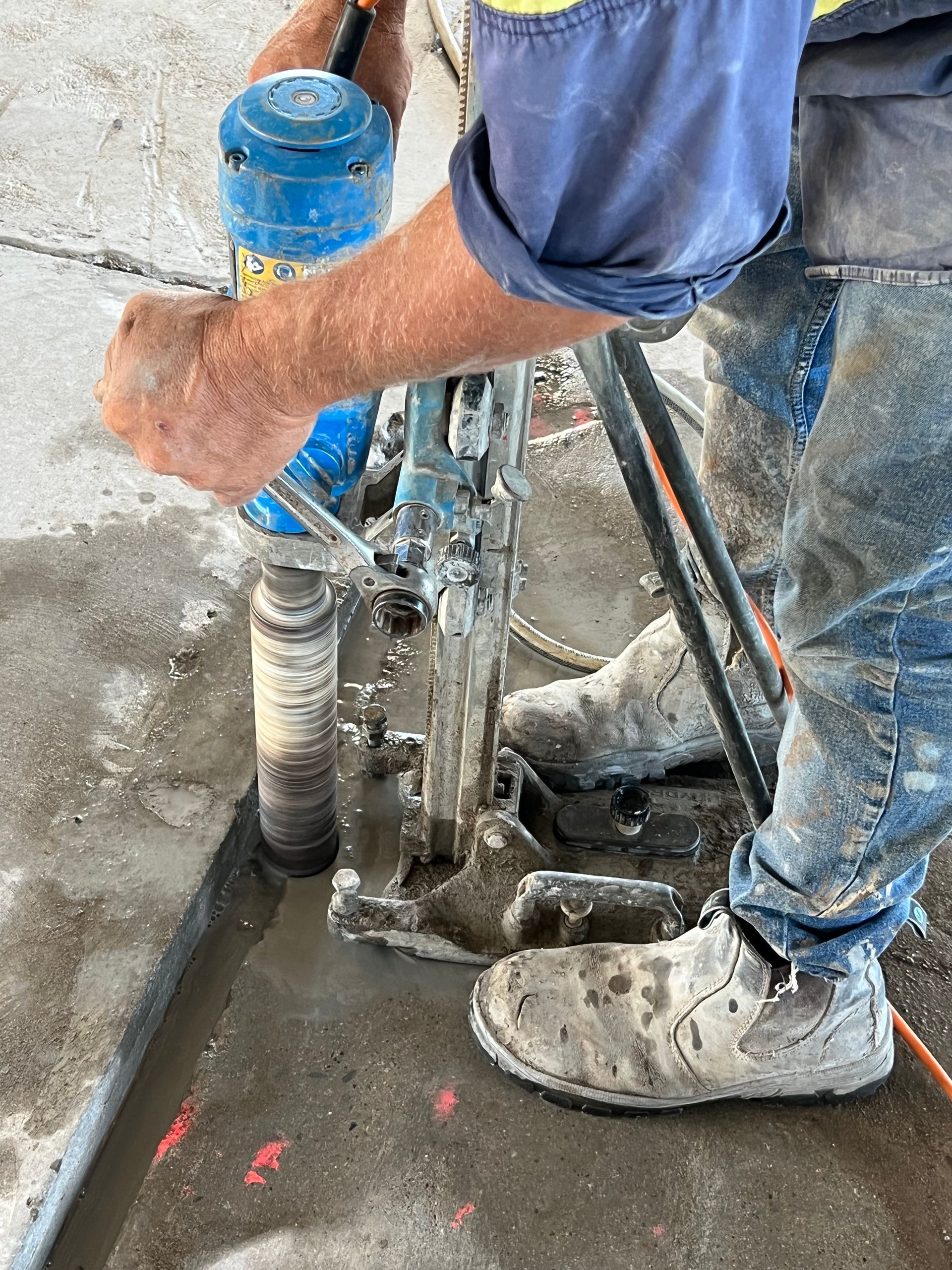 Person using a core drill to bore a hole in concrete — Ablecut Concrete Cutting & Coring In East Mackay, QLD
