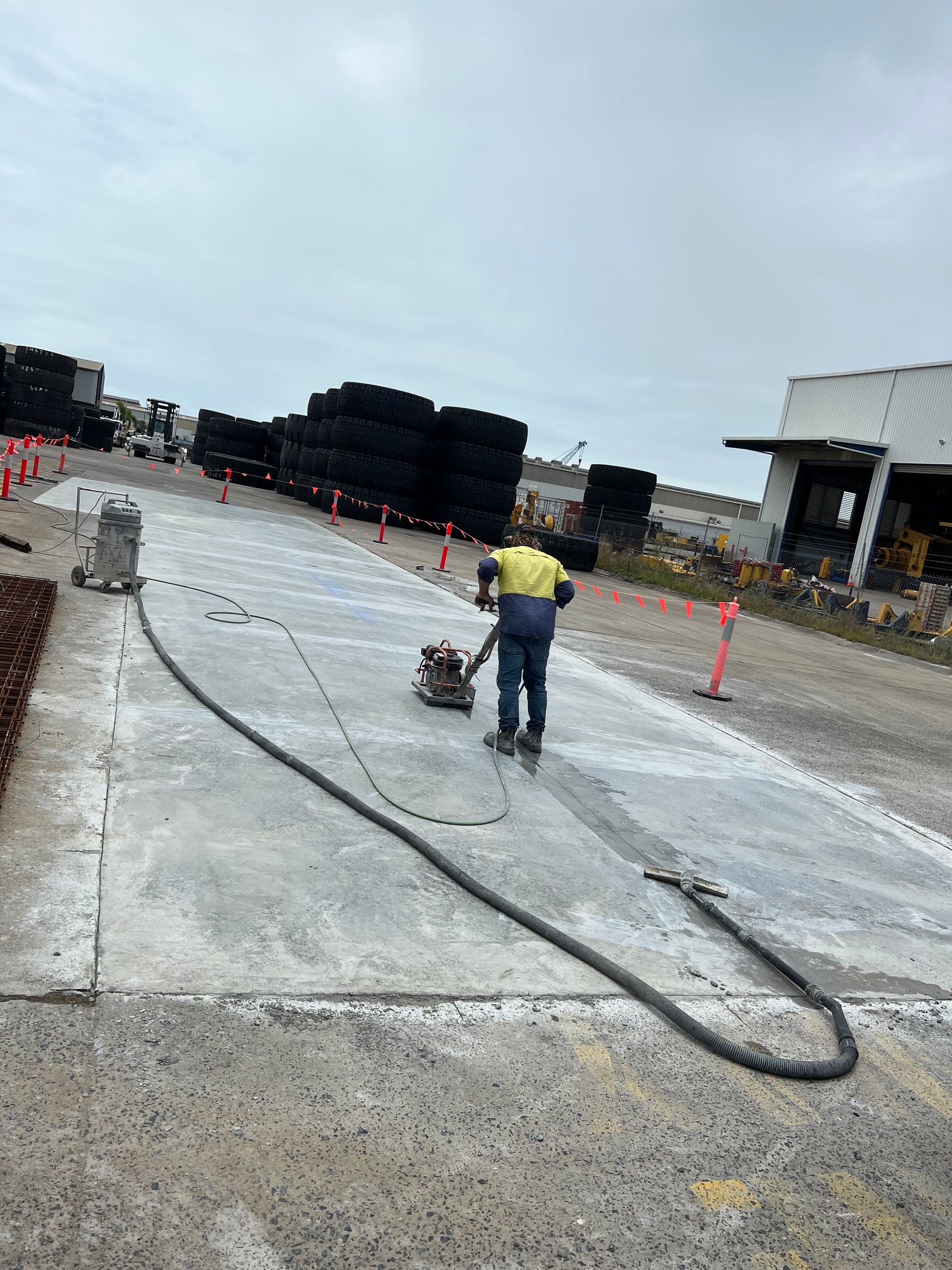 Worker using a vibrating plate compactor on a concrete surface — Ablecut Concrete Cutting & Coring In East Mackay, QLD