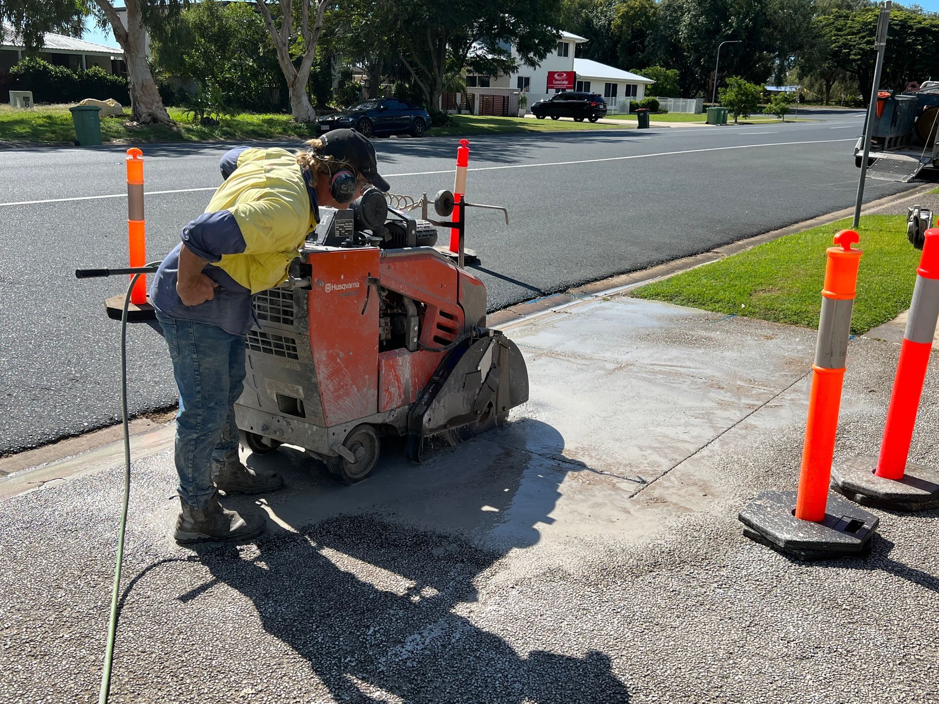 Person Using a Concrete Saw on a Sidewalk — Ablecut Concrete Cutting & Coring In East Mackay, QLD