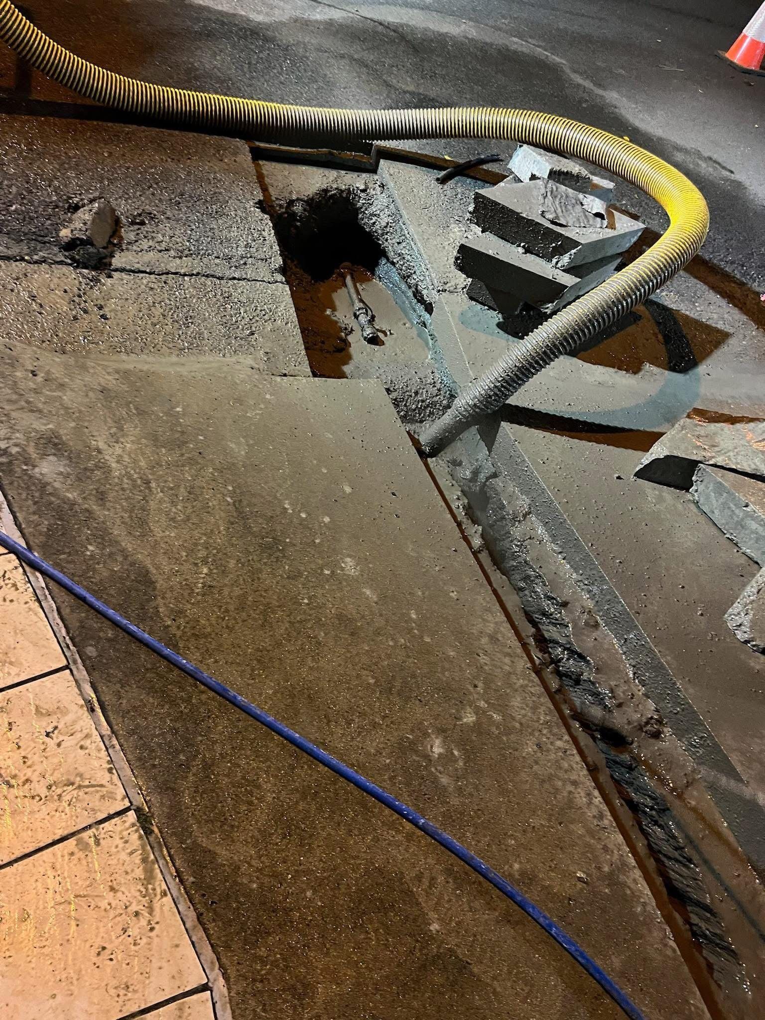 Wet concrete around a metal barricade and blue cable near tiled flooring. — Ablecut Concrete Cutting & Coring In East Mackay, QLD