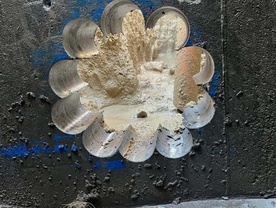 A Flower-shaped Pattern Carved Into a Dark, Textured Surface — Ablecut Concrete Cutting & Coring In East Mackay, QLD