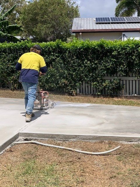 Man Using a Machine to Smooth a New Concrete Driveway — Ablecut Concrete Cutting & Coring In East Mackay, QLD