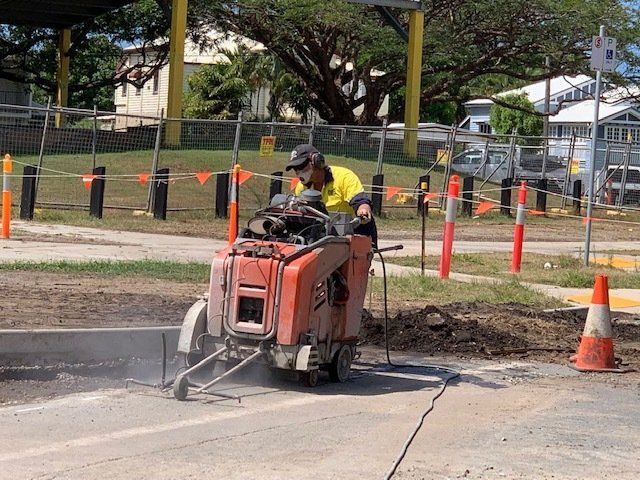 A Worker Using a Concrete Saw on a Road — Ablecut Concrete Cutting & Coring In East Mackay, QLD