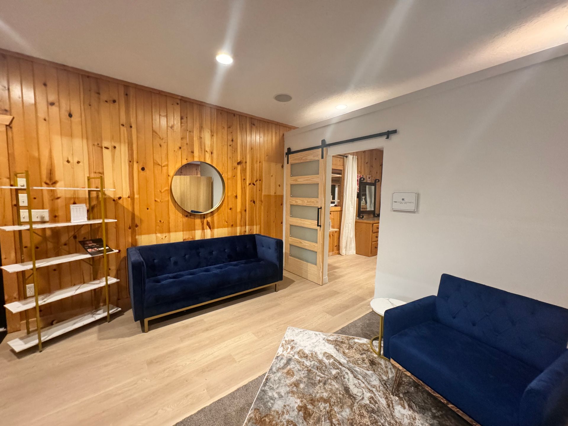 A living room with a blue couch and a sliding barn door.