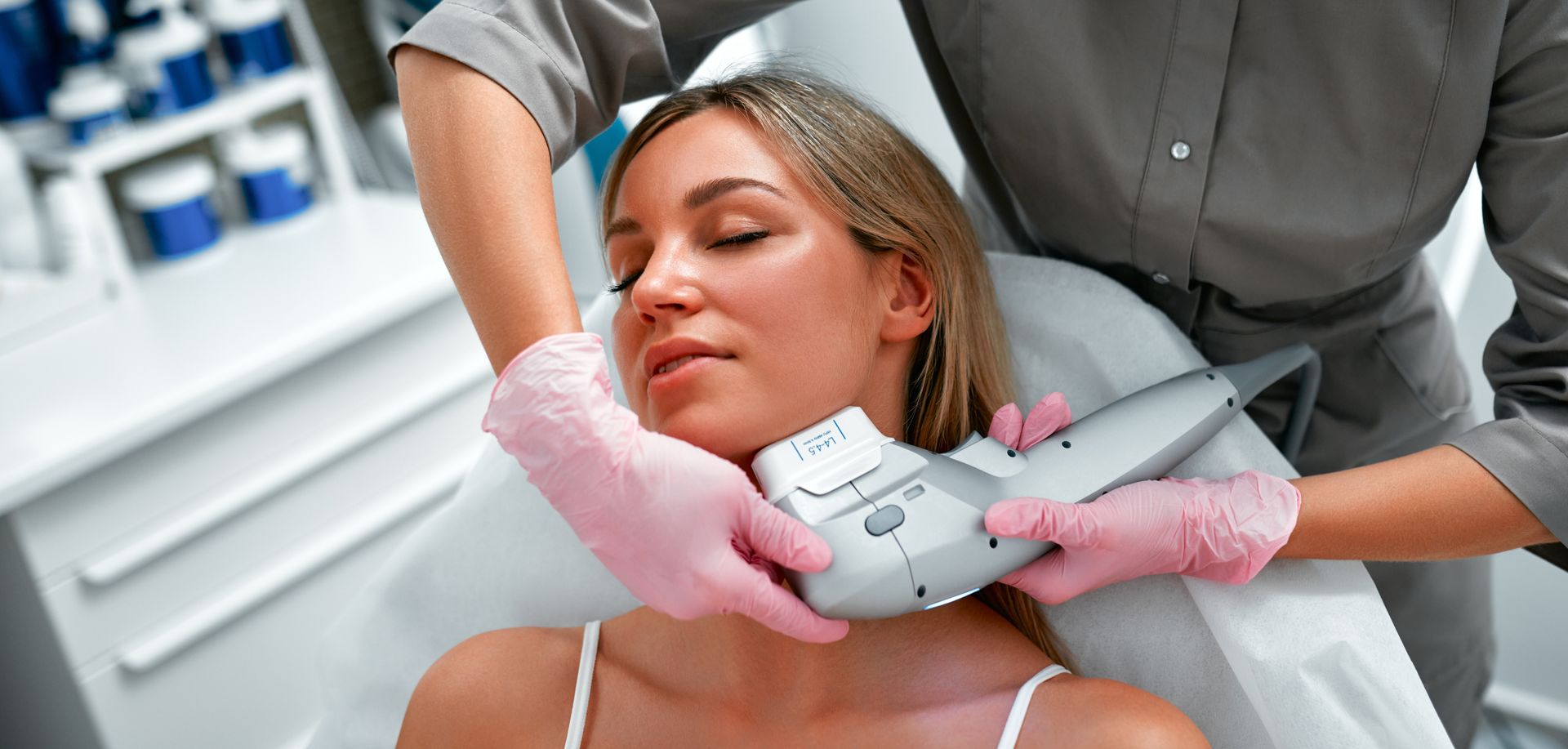 A person receiving a neck treatment from a technician in a medical setting.