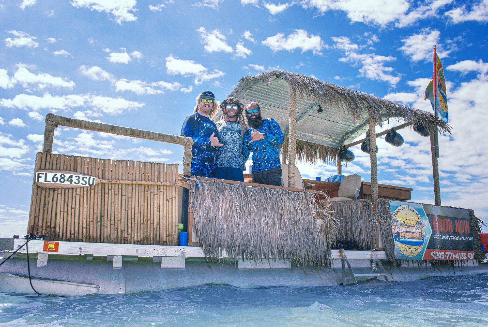 Three men on a boat smiling for a photo