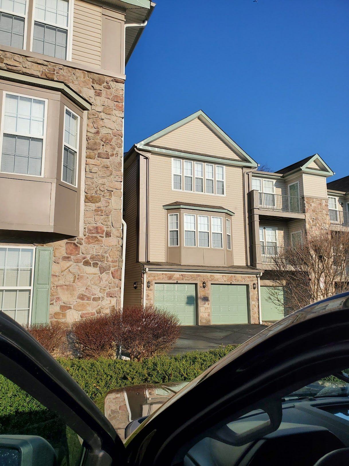 A car is parked in front of a large apartment building