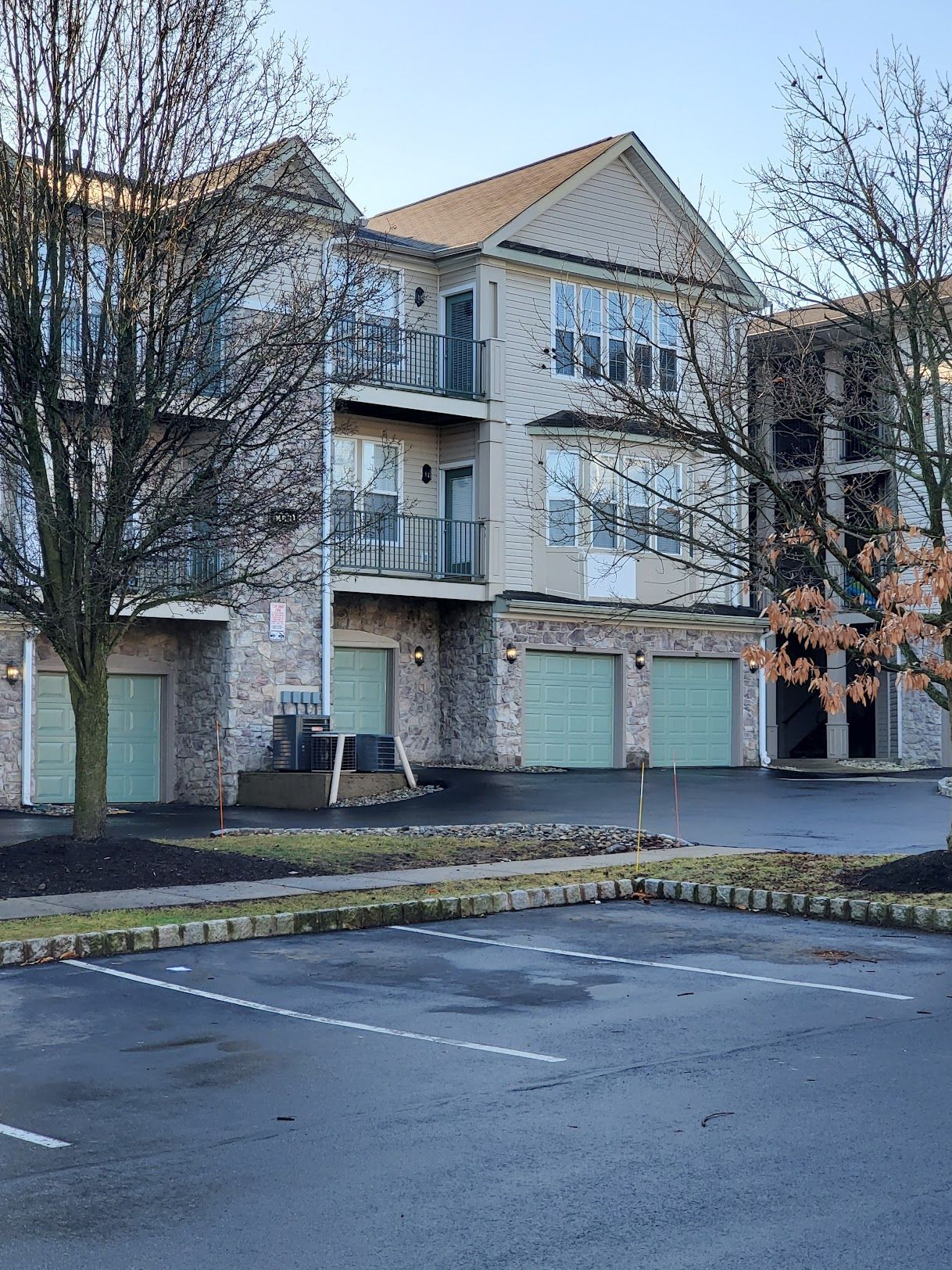 A large apartment building with a parking lot in front of it.