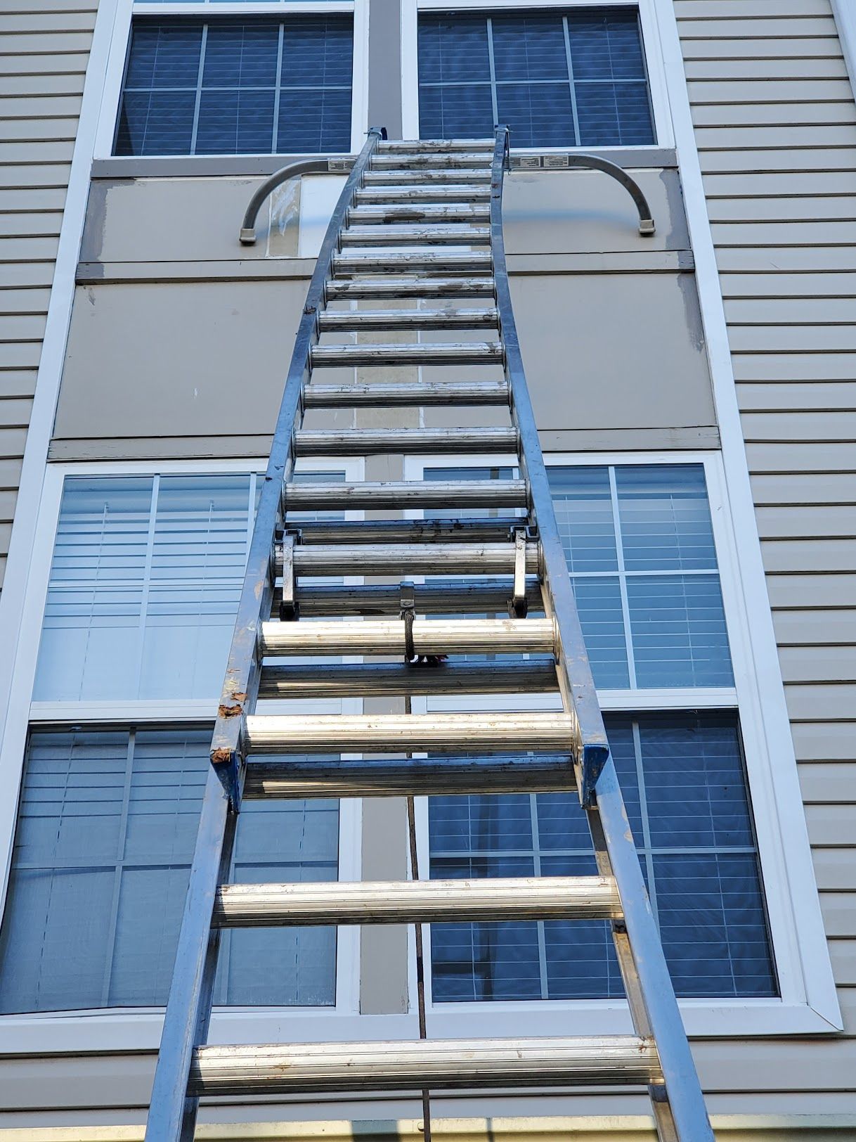 A ladder is going up the side of a building