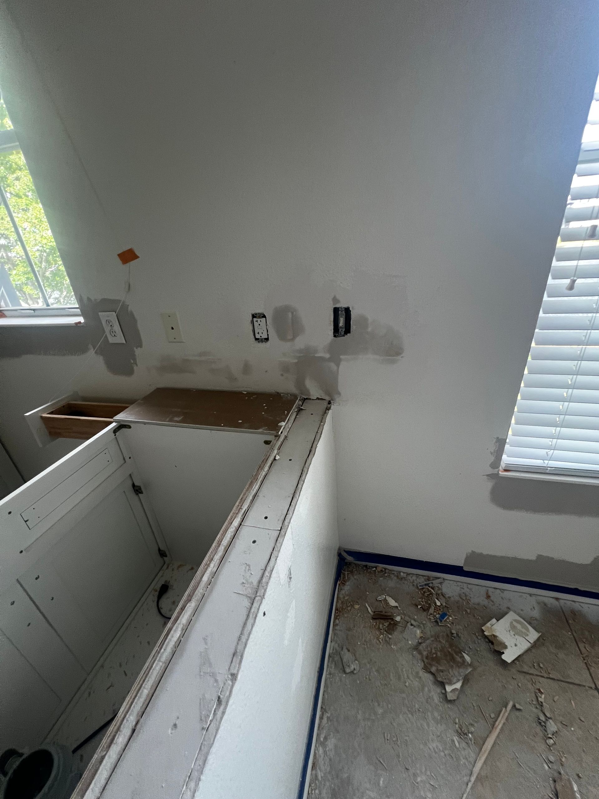 Kitchen under renovation with exposed cabinets, electrical outlets, and unfinished walls.