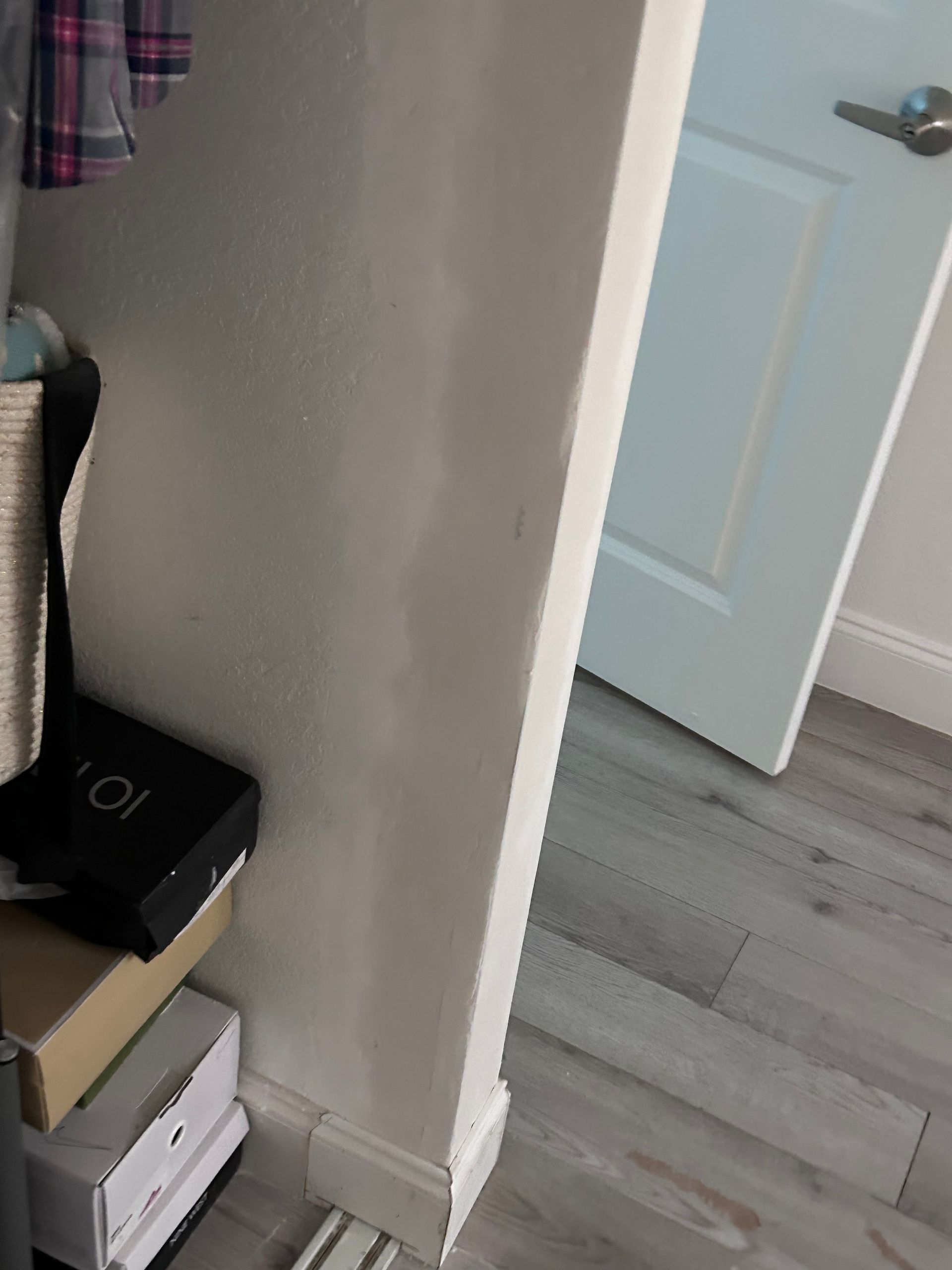 White wall and door, with partial view of open boxes on floor.